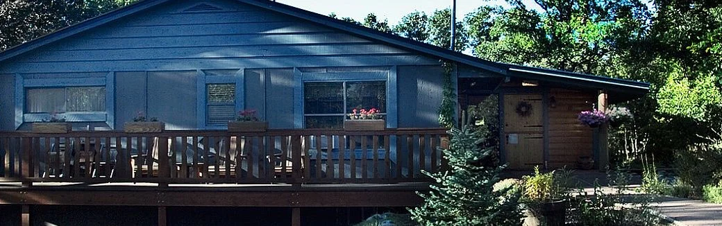 The blue ranch house and deck at Country Sunshine Bed & Breakfast