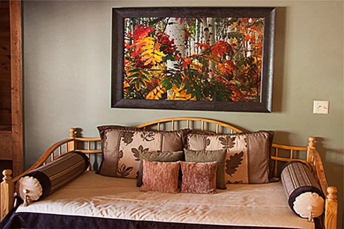 Rustic log daybed beneath a framed aspen painting in the Aspen Room