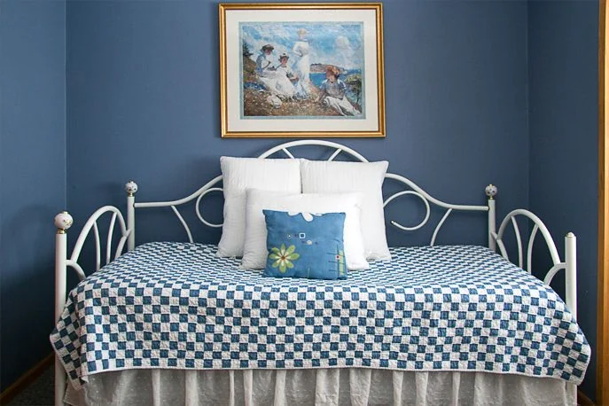 Columbine Room with a brass and white iron bed at Country Sunshine Bed & Breakfast